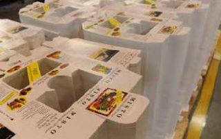 A stack of die-cut folding cartons waiting to be glued.